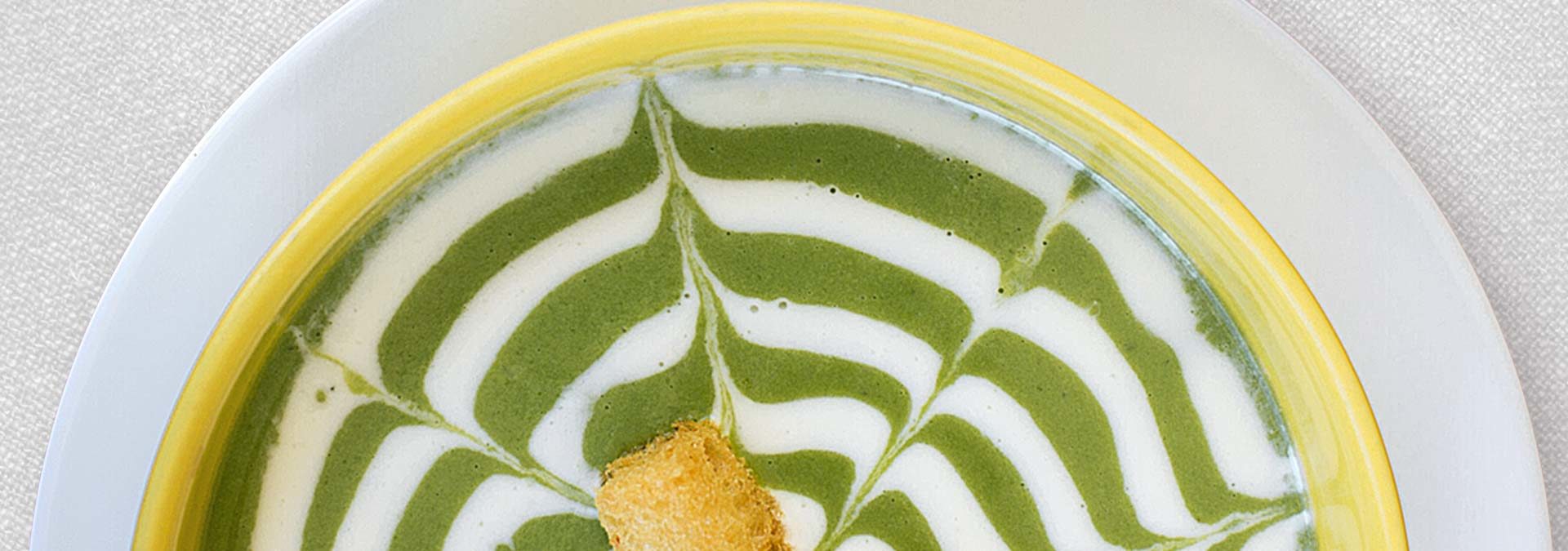 Green cream soup with artistic swirl